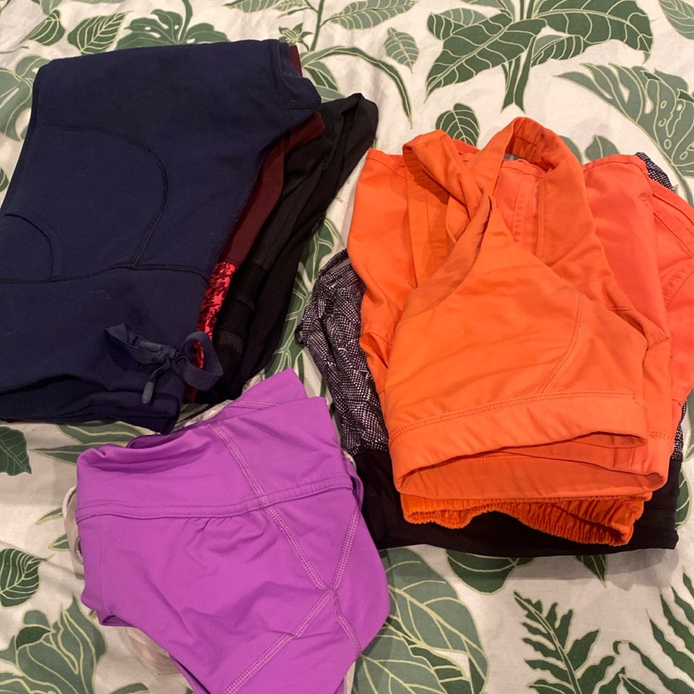 Bundle of lululemon women’s clothes: sports bras, running shorts, and leggings.